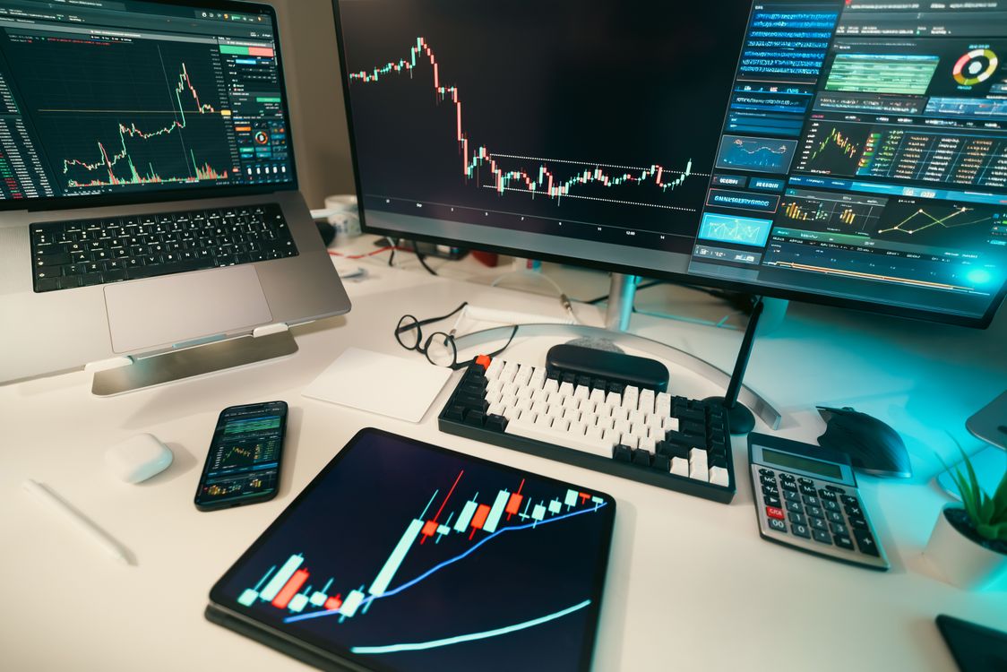 Trading desk with financial charts on screen